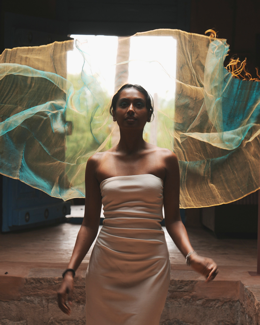 Model wearing a handwoven Sunburst Green silk scarf crafted with traditional Bengal weaving techniques, showcasing its airy, lightweight drape and luxurious texture as it flows gracefully in motion — a timeless handmade accessory blending heritage craft with contemporary design.