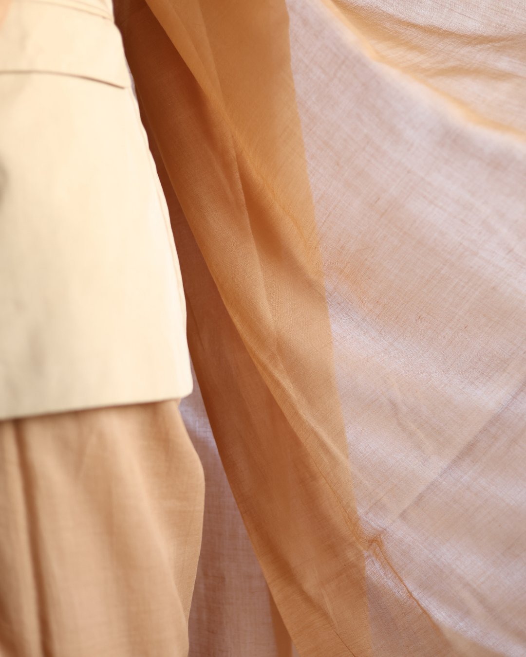 Detailed view of the DUNE handwoven cotton saree highlighting its sheer, lightweight texture and soft beige hue. Inspired by shifting desert landscapes, this breathable saree drapes effortlessly, blending minimal elegance with everyday comfort — a timeless wardrobe essential for slow, mindful fashion.