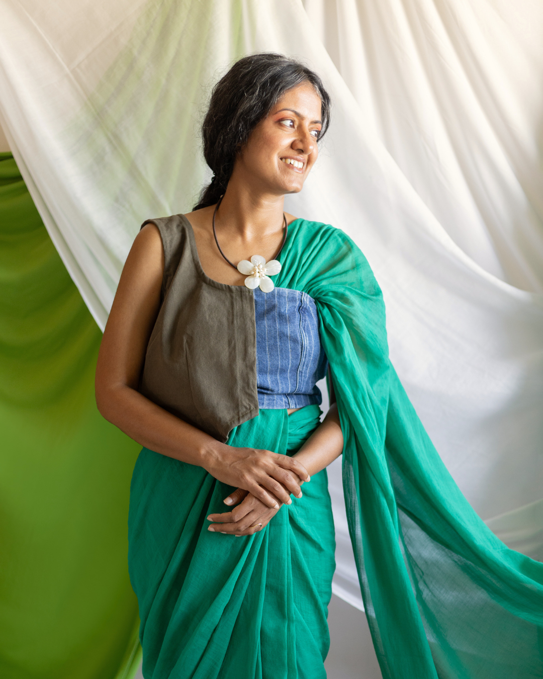 Model wearing the GROVE handwoven Bengal cotton saree in solid green, styled for effortless elegance. The lightweight, breathable fabric drapes naturally, showcasing traditional weaving techniques refined for contemporary everyday wear.