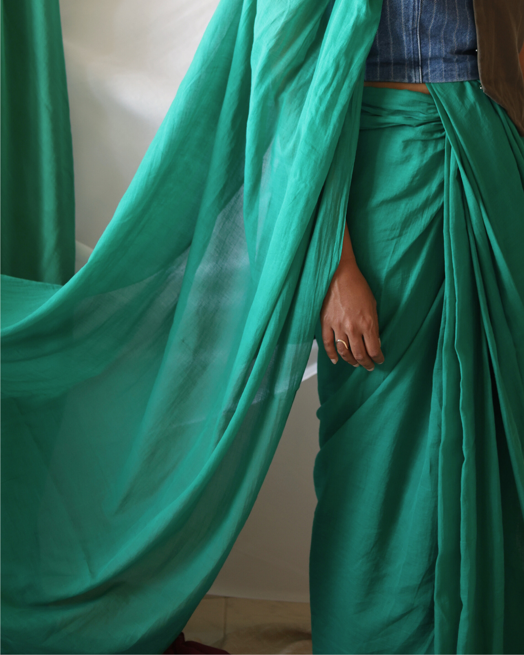 Close-up of the GROVE solid green handloom cotton saree, highlighting its fluid pallu and graceful drape. Handwoven by artisans, this sustainable saree blends tradition with timeless minimalism.