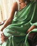 A model draped in a handwoven Bengal cotton green saree adorned with subtle woven motifs, showcasing traditional craftsmanship and lightweight comfort — a timeless, breathable saree perfect for everyday elegance and contemporary styling.