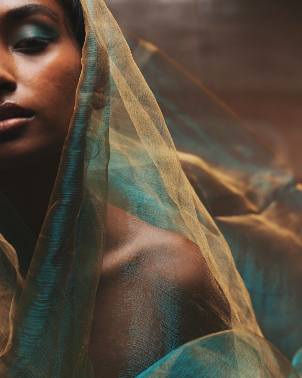 Handwoven Bengal silk scarf in sunburst green with delicate golden threads, styled as a soft drape over the shoulder. Lightweight, breathable, and crafted using traditional weaving techniques, this colour-shifting silk scarf blends heritage craftsmanship with a modern look.