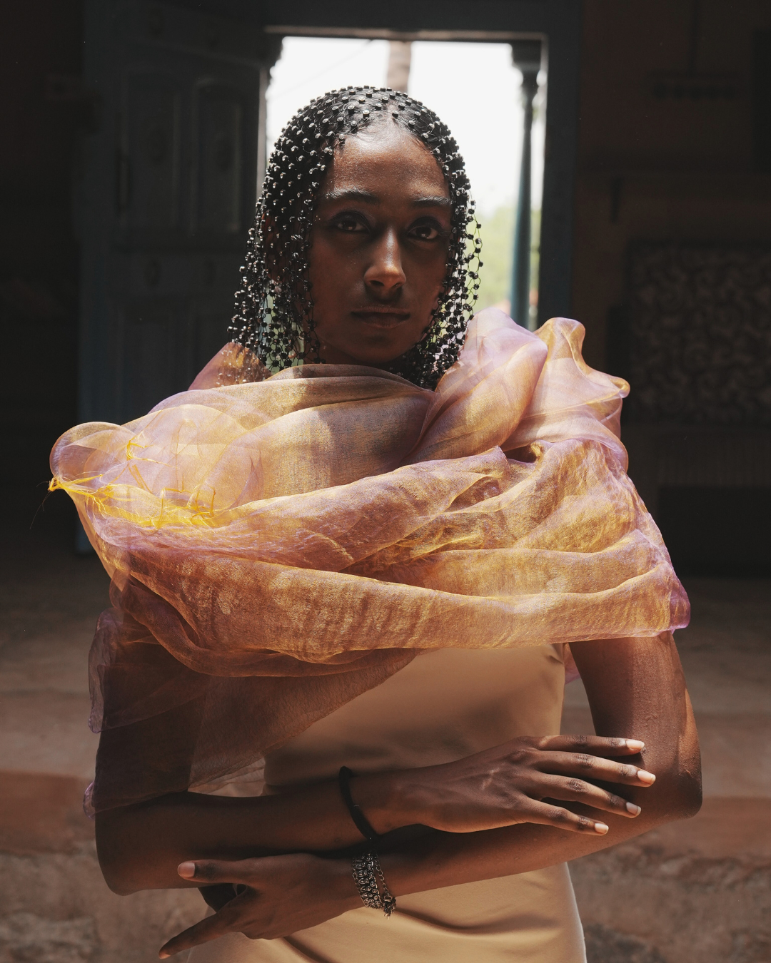 Model draped in the Sunburst Purple handwoven dual-tone silk scarf, glowing in shifting hues of blush and gold. Crafted in Phulia, West Bengal, this featherlight 19g luxury wrap embodies Indian textile heritage and slow fashion, designed for timeless versatility and contemporary elegance.
