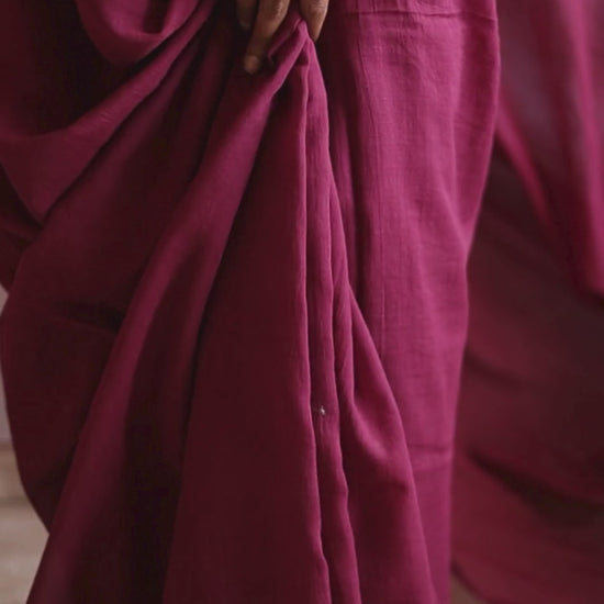 Close-up video of the POMEGRANATE pure Bengal cotton red saree, showing the soft pleats and natural drape in motion. The deep crimson fabric flows gracefully, highlighting its lightweight, handwoven texture and artisanal craftsmanship.