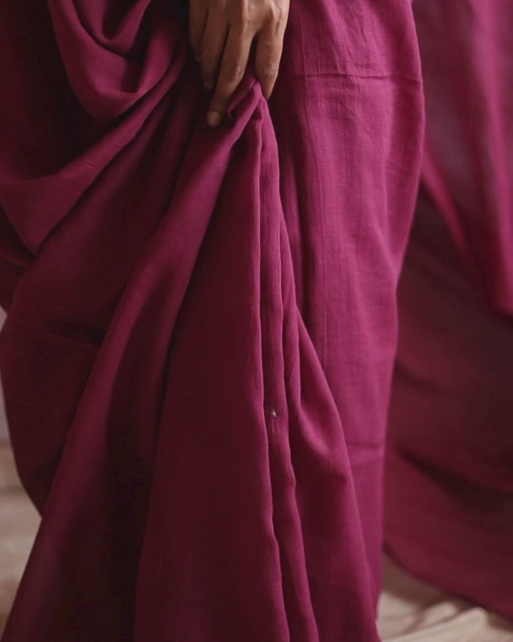 Close-up video of the POMEGRANATE pure Bengal cotton red saree, showing the soft pleats and natural drape in motion. The deep crimson fabric flows gracefully, highlighting its lightweight, handwoven texture and artisanal craftsmanship.
